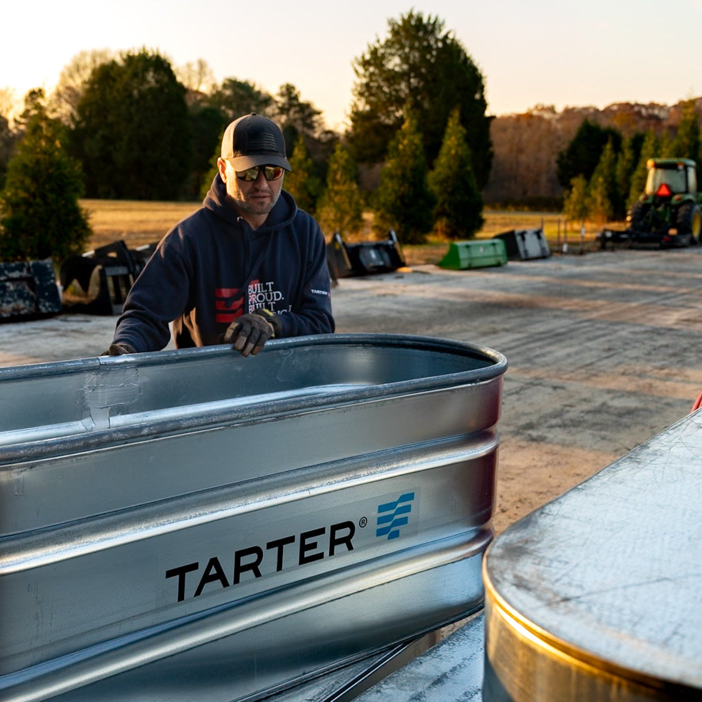 Person working on a metal Tarter product in an outdoor setting